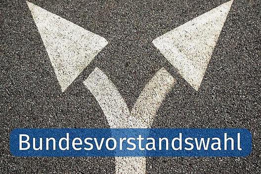 Wegweiser. Quelle: CanvaPro Auf die Straße aufgemalte Pfeile, die sich in in zwei Richtungen teilen. Dazu das Wort "Bundesvorstandswahl".