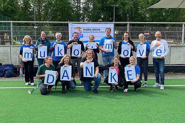 Menschen mit Schildern: muko.move Danke. Die Geschäftsstelle des Mukoviszidose e.V. bedankt sich bei allen, die beim muko.move 2023 dabei waren. 