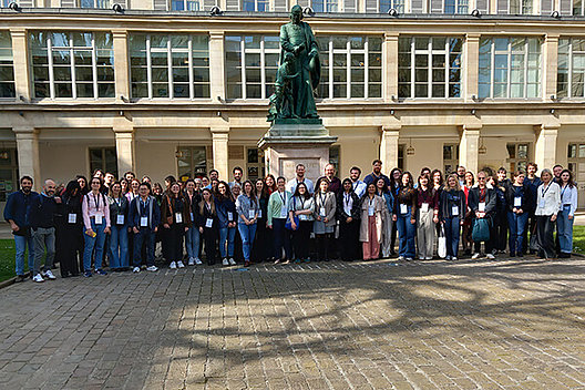 Gruppenfoto der Teilnehmer des European CF Young Investigators' Meeting Gruppenfoto von etwa 40 Personen vor einem historisch aussehenden Gebäude mit einer Bronzestatue