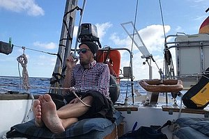 Mann auf Segelboot inhaliert. 