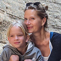 Leni mit ihre Mutter Bianka-Rebekka umarmt ihre Tochter Leni fest. Im Hintergrund sieht man Felsen. Leni hat Mukoviszidose.
