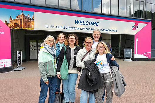 Gruppenfoto von Menschen vorm Eingang der Europäischen CF-Konferenz in Glasgow, darunter Stephan Kruip, Vorstandsvorsitzender des Mukoviszidose e.V. 