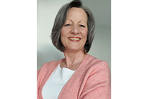 Porträt von Simona, dunkle halblange Haare, rosa Strickjacke. Simona ist 57 Jahre alt und hat Mukoviszidose. 