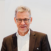 Stephan Kruip, Vorstandsvorsitzender des Mukoviszidose e.V. und selbst Mukoviszidose-Patient Porträt: Stephan Kruip, Vorstandsvorsitzender des Mukoviszidose e.V. und selbst Mukoviszidose-Patient, ein ungefähr 60-jähriger Mann mit dunklen Haaren vor einem weißen Hintergrund.