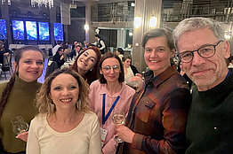 Gruppenfoto von fünf Frauen und einem Mann, scheinbar in einem Tagungsgebäude. 