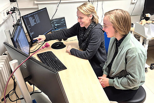 PD Dr. Hentschel und Maike Karnstedt sitzen am Schreibtisch und schauen auf Computerbildschirme.