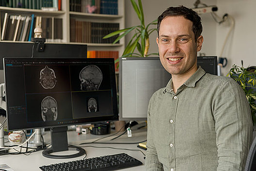 Dr. sc. hum. Niclas Hagen sitzt am Schreibtisch vor seinem Computerbildschirm.