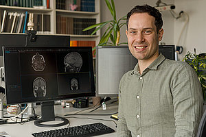 Dr. sc. hum. Niclas Hagen sitzt am Schreibtisch vor seinem Computerbildschirm.