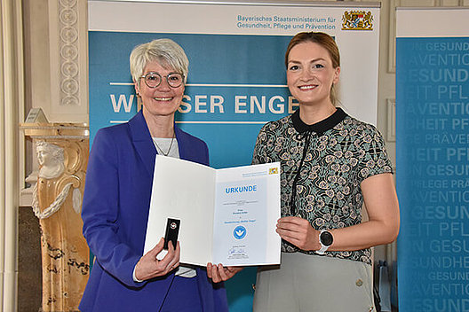Rosalie Keller von der Regionalgruppe Unterfranken des Mukoviszidose e.V. wurde mit dem Weißen Engel ausgezeichnet. Rosalie Keller von der Regionalgruppe Unterfranken des Mukoviszidose e.V. wurde mit dem Weißen Engel ausgezeichnet (im Bild sieht man sie mit der Urkunde in der Hand gemeinsam mit einer weiteren Frau).