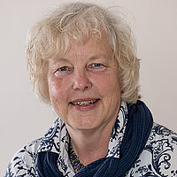 Porträtfoto von Helga Nolte, weiße lockige Haare, lächelt