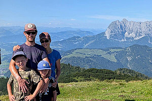 Familienfoto: Eltern, zwei Jungen vor Bergkulisse