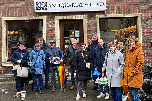 Im März 2024 traf sich die Regionalgruppe Münster des Mukoviszidose e.V. mit Vertretern des Bundesverbands. Gruppe von Menschen bei schlechtem Wetter vor Buchhandlung: Im März 2024 traf sich die Regionalgruppe Münster des Mukoviszidose e.V. mit Vertretern des Bundesverbands.