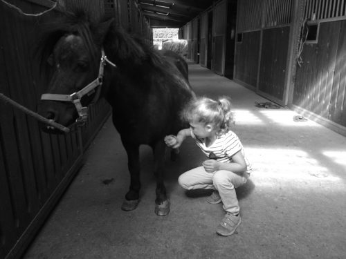 Kind im Pferdestall
