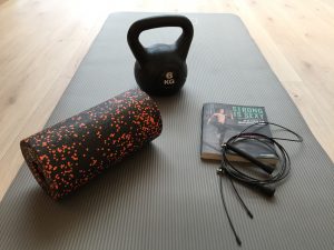 Mein "Starterkit" für das Training: Buch, Matte, Springseil, Kettlebell und Blackroll für Dehnübungen.