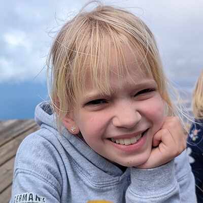 Porträt von Leni. Sie lächelt, hat blonde Haare. 