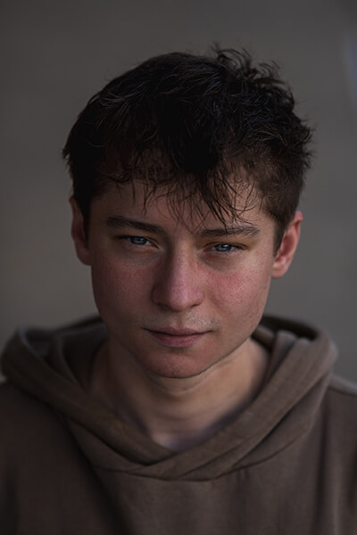 Porträt von Jonas, junger Mann, dunkler Kapuzenpullover, dunkle Haare