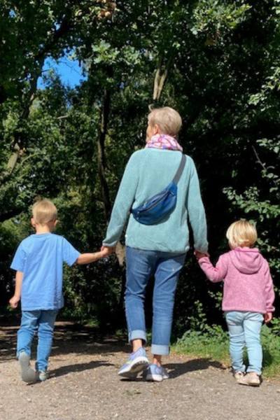 Waltraud geht mit ihren beiden Enkelkindern an der Hand spazieren