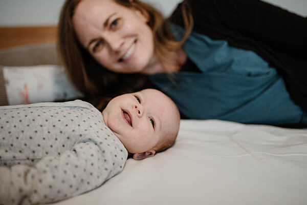 Alicia mit ihrem jüngsten Sohn Ein lachendes Baby liegt vor seiner lachenden Mutter.