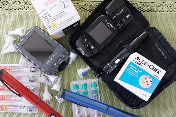 Blutzuckerteststreifen, Testgeräte, Sensoren - das gehört bei Diabetes dazu. Auf dem Foto sieht man verschiedene Dinge, die man bei Diabetes benötigt. 