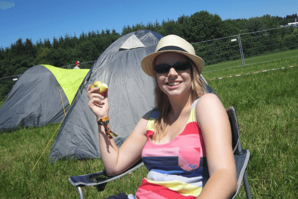 Zoë isst einen Apfel beim Festival. 