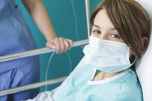 Mit Mundschutz im Krankenbett
