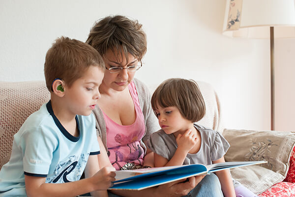 Eine Mutter liest ihren Kindern vor. 