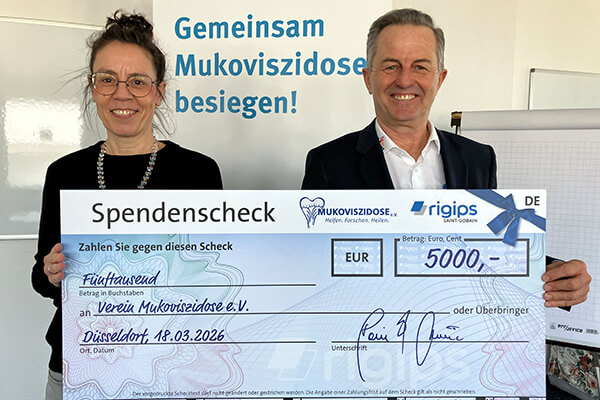 Scheckübergabe: Eine Frau und ein Mann halten einen Spendenscheck in Höhe von 5.000 Euro im Hintergrund liest man den Schriftzug "Gemeinsam Mukoviszidose besiegen".